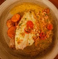 Healthy fish meal of fried plaice with carrots and tomatoes on plate