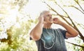 Healthy, fit and active senior man listening to music while running, exercising and training outside from below. Happy Royalty Free Stock Photo