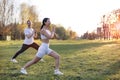 Healthy and fit mixed race couple practice yoga stretching outdoors together in the expansive lawn lush green park Royalty Free Stock Photo