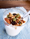 Healthy flavored yogurt in glass cup and spoon with cereal and g