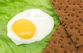 Healthy food background: fried eggs, lettuce, crisp bread