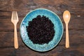 Healthy food black rice in blue plate on wood table. Royalty Free Stock Photo