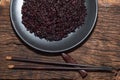 Healthy food black rice in plate on wood table. Royalty Free Stock Photo