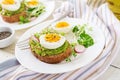 Avocado egg sandwich with whole grain bread on white wooden background. Royalty Free Stock Photo