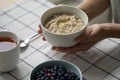 Healthy food breakfast with oatmeal porridge in bowl with summer berries, slice of butter, mug tea. Royalty Free Stock Photo