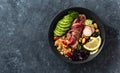Healthy food buddha bowl with beef steak, beans, couscous, avocado and vegetables dark background with copy space