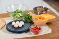 Healthy food clean eating selection for salad on wooden table : eggs, leaf vegetable, pumpkin, cherry tomatoes, potato