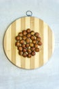 Flat lay, close-up of hazelnuts on a round bamboo board. Macro, selective focus, vertical photo, top view.