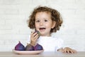 Child happily eat fresh figs.