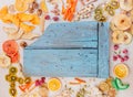 Dried fruit and vegetable chips, candied pumpkin slices, nuts and seeds around cutting board Royalty Free Stock Photo