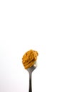 Healthy food concept. Peanut butter smear on a metal spoon isolated on white background