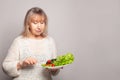 Healthy food concept. Smiling senior woman eating salad on gray banner background Royalty Free Stock Photo