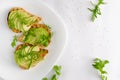 Healthy food concept. Toasts with avocado, shrimps and arugula on white background. Top view, flat lay. Copy space