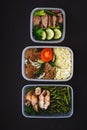 The healthy food in the containers on black background: snack, dinner, lunch. Baked fish, beans, beef cutlets, mashed potatoes, me Royalty Free Stock Photo