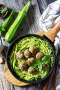 Healthy food. Cooked zucchini noodles with meatballs in a cast iron skillet on a rustic table.