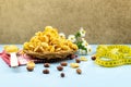 Healthy food cornflakes in a wicker plate on a red towel with chamomile flower, centimeter tape and wooden spoon