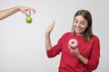 Healthy food and diet concept. Beautiful young woman choosing between fruits and sweets. Royalty Free Stock Photo