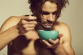 Healthy food and dieting, fitness, morning. man with bare chest eating breakfast of oatmeal with milk Royalty Free Stock Photo