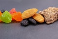 Healthy food. Dried fruits: nuts, raisins, almonds, multi-colored candied fruits, a piece of chocolate on a gray background Royalty Free Stock Photo