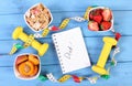 Healthy food, dumbbells, centimeter and notebook for notes, slimming, healthy and sporty lifestyle Royalty Free Stock Photo