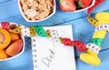 Healthy food, dumbbells, centimeter and notebook for notes, slimming, healthy and sporty lifestyle Royalty Free Stock Photo