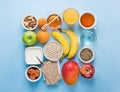 Healthy Food Fiber Source Breakfast Oatmeal Honey Fruits Apples Banana Mango Orange Juice Water Green Tea Nuts.Light Blue Tabletop