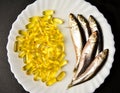 Healthy food, fish oil pills and fish on a plate Royalty Free Stock Photo