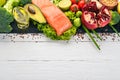 Healthy food. Fish salmon, avocado, broccoli, fresh vegetables, nuts and fruits. On a white wooden background. Royalty Free Stock Photo