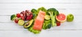 Healthy food. Fish salmon, avocado, broccoli, fresh vegetables, nuts and fruits. On a white wooden background. Royalty Free Stock Photo