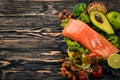 Healthy food. Fish salmon, avocado, broccoli, fresh vegetables, nuts and fruits. On a wooden background. Royalty Free Stock Photo