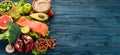 Healthy food. Fish salmon, avocado, broccoli, fresh vegetables, nuts and fruits. On a wooden background. Royalty Free Stock Photo