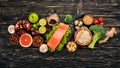 Healthy food. Fish salmon, avocado, broccoli, fresh vegetables, nuts and fruits. On a wooden background. Royalty Free Stock Photo