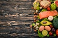 Healthy food. Fish salmon, avocado, broccoli, fresh vegetables, nuts and fruits. On a wooden background. Royalty Free Stock Photo