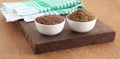 Healthy Food Flaxseeds and Flaxseeds Powder in Bowls on Wooden Board