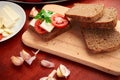 Healthy food - fresh bread and feta cheese on a wooden background, tomatoes, greens and vegetables Royalty Free Stock Photo