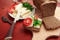 Healthy food - fresh bread and feta cheese on a wooden background, tomatoes, greens and vegetables Royalty Free Stock Photo