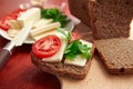 Healthy food - fresh bread and feta cheese on a wooden background, tomatoes, greens and vegetables Royalty Free Stock Photo