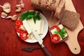 Healthy food - fresh bread and feta cheese on a wooden background, tomatoes, greens and vegetables Royalty Free Stock Photo