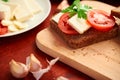 Healthy food - fresh bread and feta cheese on a wooden background, tomatoes, greens and vegetables Royalty Free Stock Photo