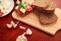 Healthy food - fresh bread and feta cheese on a wooden background, tomatoes, greens and vegetables Royalty Free Stock Photo