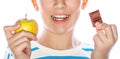 Healthy food, good teeth. Bad food bad teeth. Little boy holding an apple and a chocolate in her hands. Cute little boy Royalty Free Stock Photo