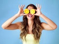 Healthy food is happy food. Studio shot of a young woman covering her eyes with oranges against a blue background. Royalty Free Stock Photo