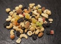 Healthy food; hazelnuts, almonds, cashew, raisin and dried fruits on a stone black background. Royalty Free Stock Photo
