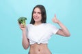 Healthy food, health lifestyle, diet. Beautiful woman eating fresh vegetable green broccoli, shows thumb up. Vegan meal Royalty Free Stock Photo