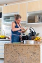 Happy woman is preparing proper meal in the kitchen