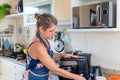 Happy woman is preparing proper meal in the kitchen