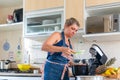 Happy woman is preparing proper meal in the kitchen