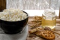 Healthy food: homemade cheese in a black round plate stands on a wooden table next to a jar of honey