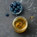 Blueberries and honey on dark background, top view