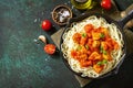 Healthy food, Italian pasta. Spaghetti with chicken and vegetables in tomato sauce in a cast iron skillet on a stone countertop. Royalty Free Stock Photo